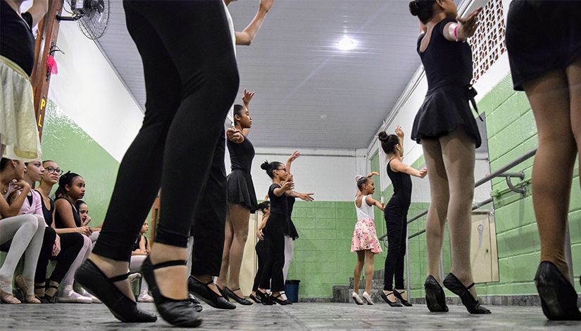 Imagem mostra meninas fazendo uma apresentação de balé.