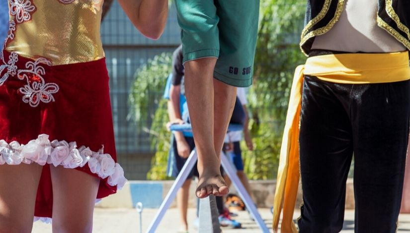 foto das pernas de pessoas se equilibrando em uma trave