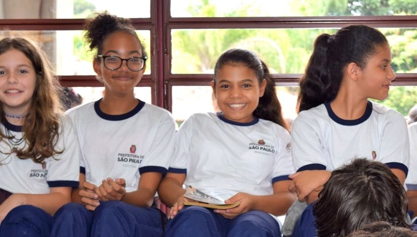 Estudantes sorrindo e usando uniforme escolar