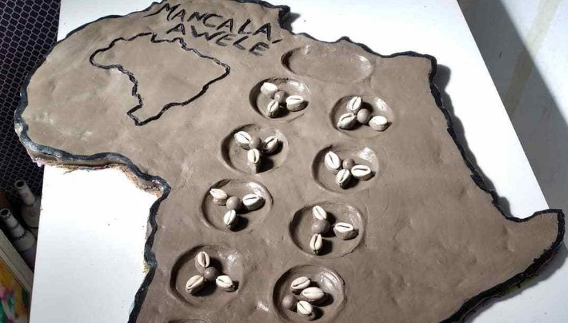 Imagem mostra jogo de Mancala Awelé.