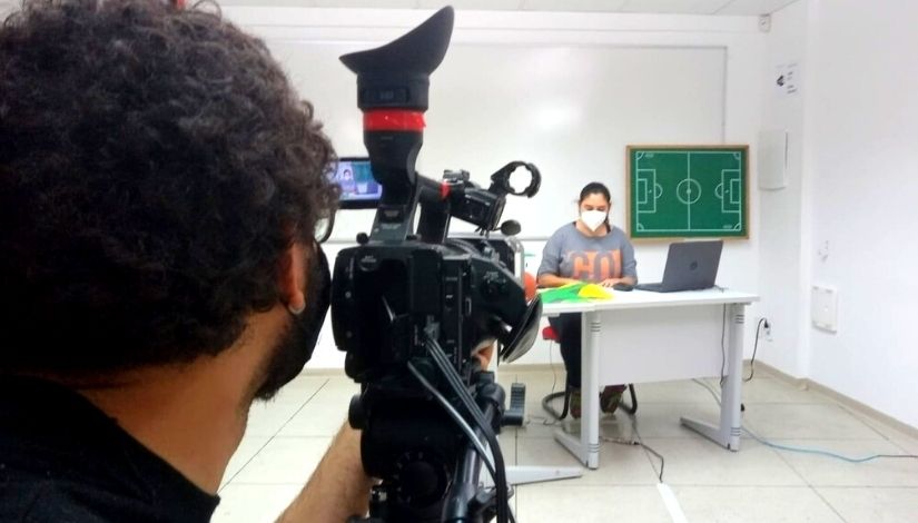 fotografia de professora sendo gravada enquanto dá aula