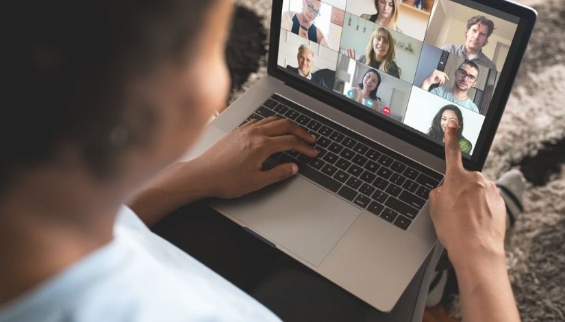 foto de uma pessoa em frente ao mu notebook com reunião virtual