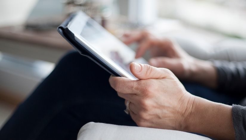 Imagem com recorte de duas mãos segurando um tablet.