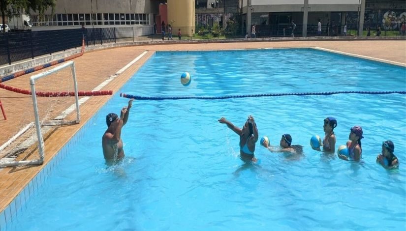 Crianças aprendendo polo aquático na piscina