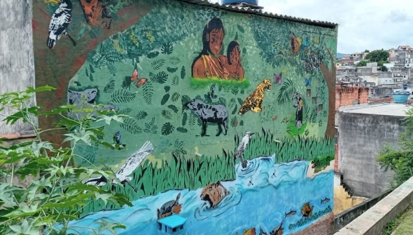 Fotografia do mural de graffiti chamado "Pindorama" com imagens da flora, fauna e povos originários.