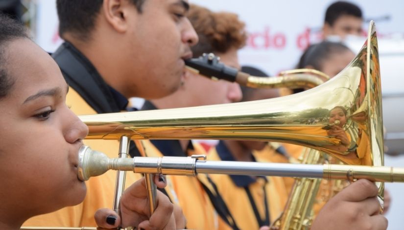 Imagem mostra uma menina tocando saxofone