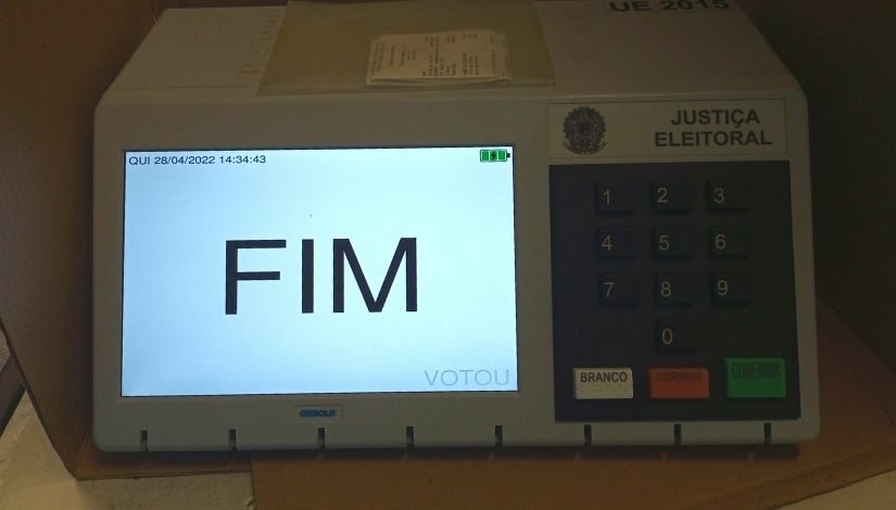 Imagem de uma urna eletrônica com a palavra 'FIM' na tela.