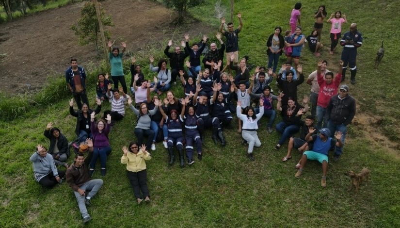 Fotografia aérea de um grupo de pessoas sentados na grama no CECI Tenondé Porã.