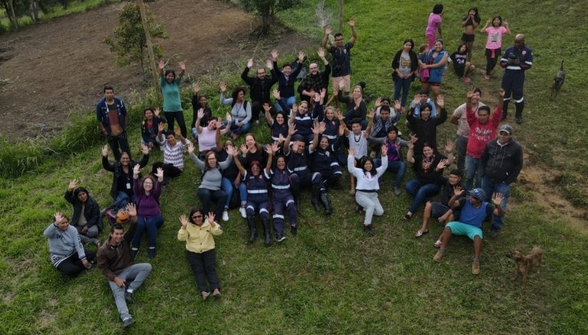 Fotografia aérea de um grupo de pessoas sentados na grama no CECI Tenondé Porã.