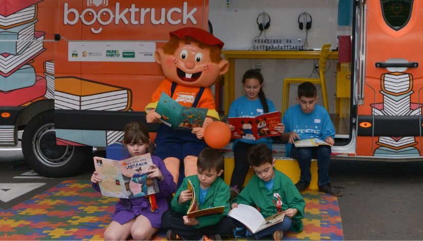 fotografia de crianças lendo na frente de um furgão da Booktruck