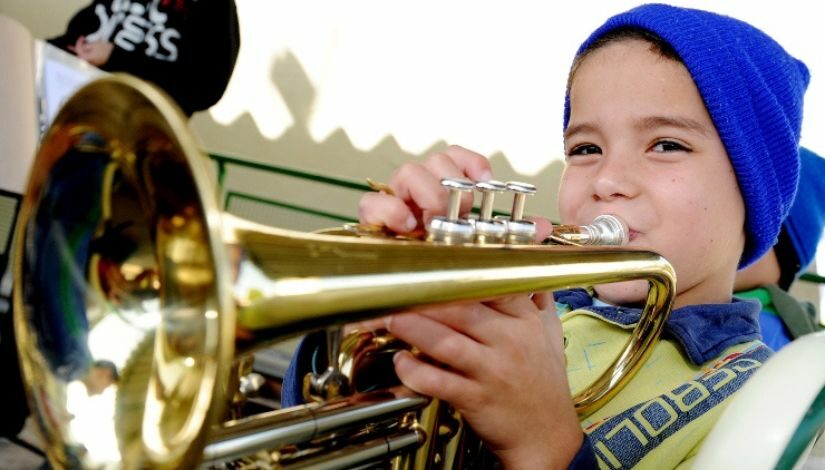 Fotografia de um menino tocando trompete