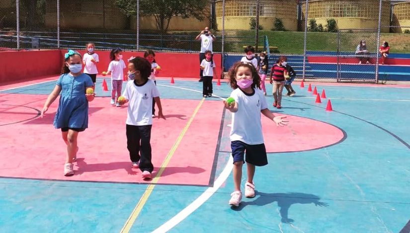 fotografia de crianças fazendo esporte em uma quadra poliesportiva 