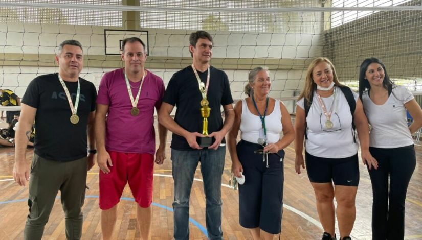 Foto tirada na premiação, onde mostra os professores responsáveis por cada equipe de cada escola recebendo o troféu e as medalhas