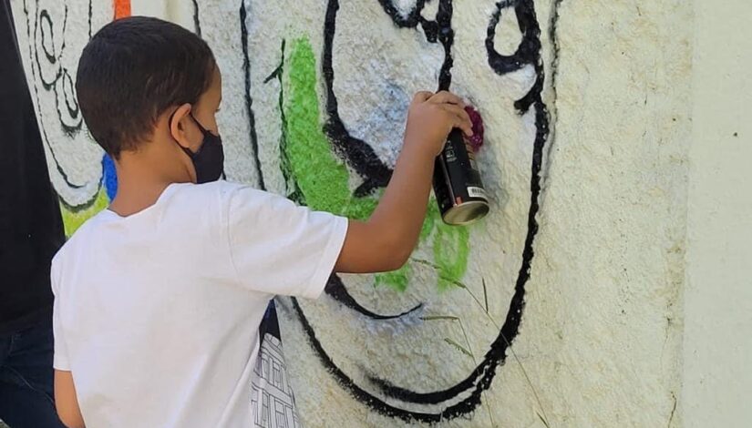 foto de estudante Surdo Grafitando o muro da escola
