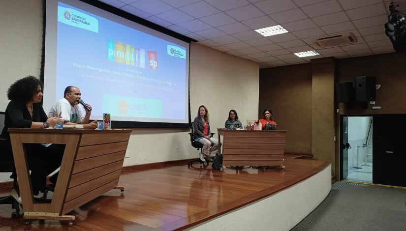 fotografia de pessoas em um palco de auditório Pmlllb