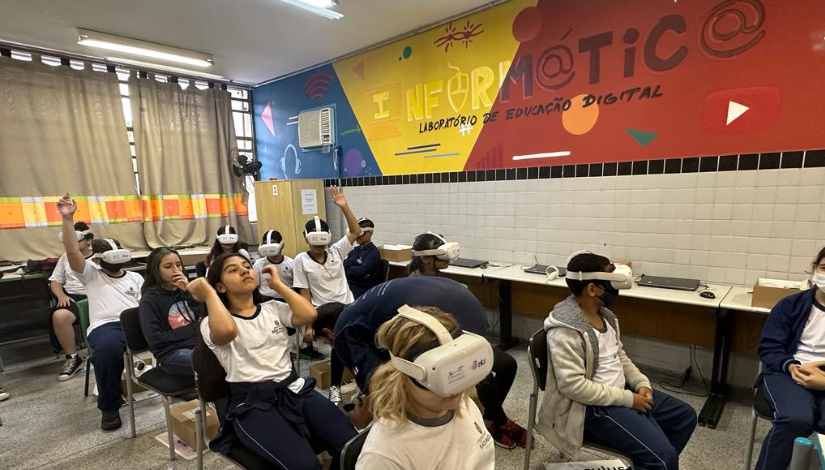 Grupo de estudantes sentados em cadeiras com óculos de realidade virtual