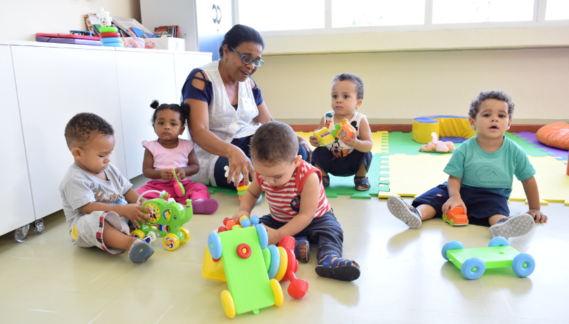 Fotografia de uma professora brincando com bebês