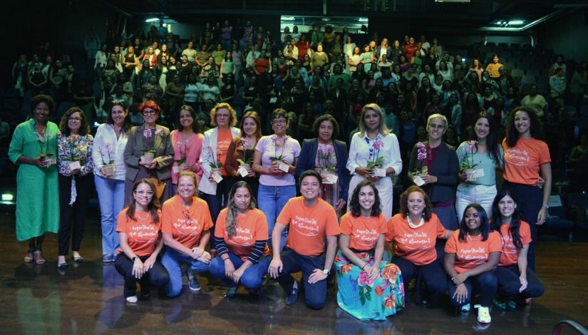 Imagem de um grupo de pessoas no palco posando para a foto.