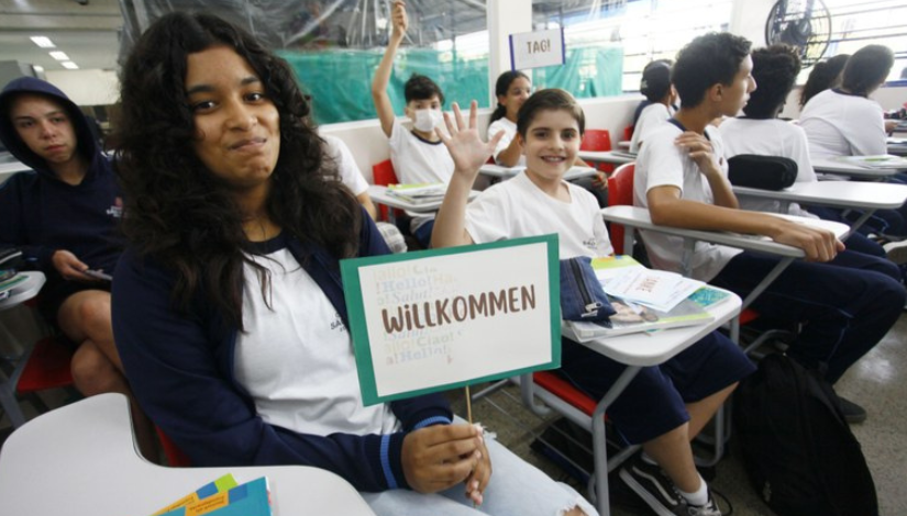 Menina está segurando uma placa onde está escrito 