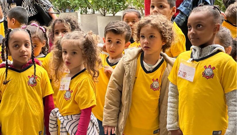 Fotografia de crianças usando camisetas amarelas do Corinthians.