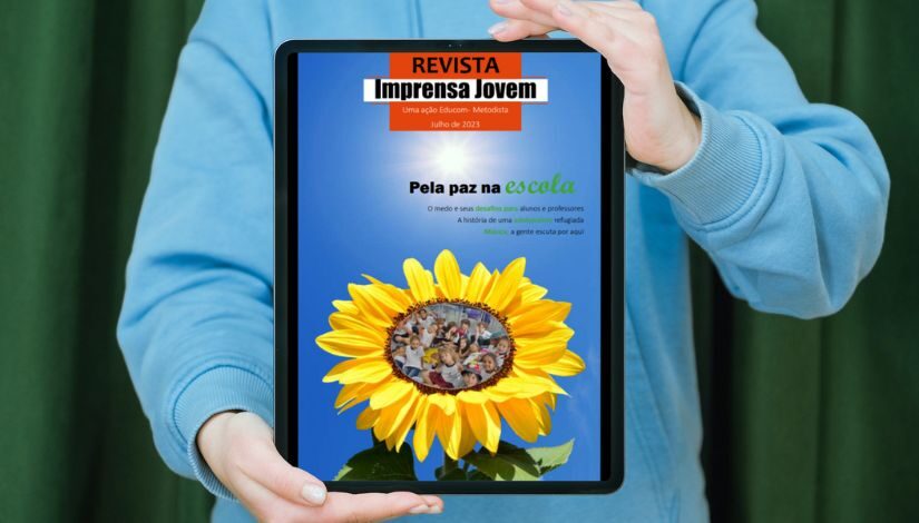 Imagem com uma pessoa segurando um tablet com a capa da Revista Imprensa Jovem.