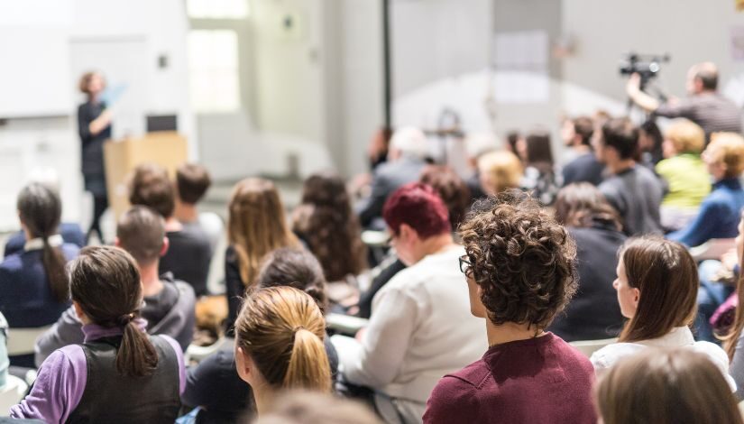 Fotografia de um auditório de momento de palestra.