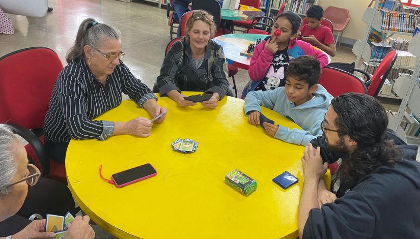 foto de pessoas de diversas idades em um jogo de cartas