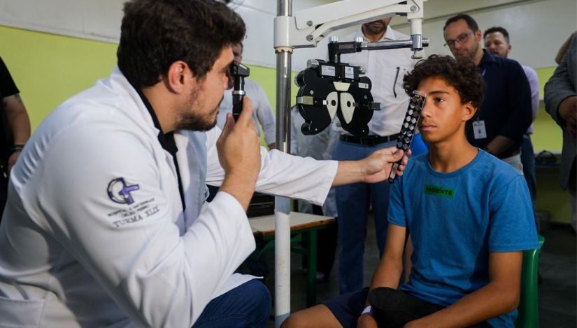 Estudante tendo olhos examinados por um profissional da Oftalmologia