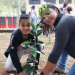 Famílias e estudantes plantando mudas