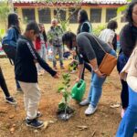 Famílias e estudantes plantando mudas