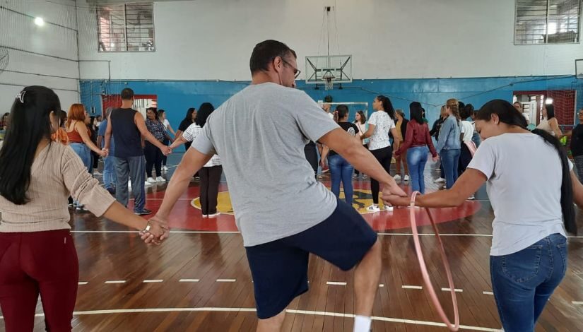 Fotografia de pessoas em roda com as mãos dadas.