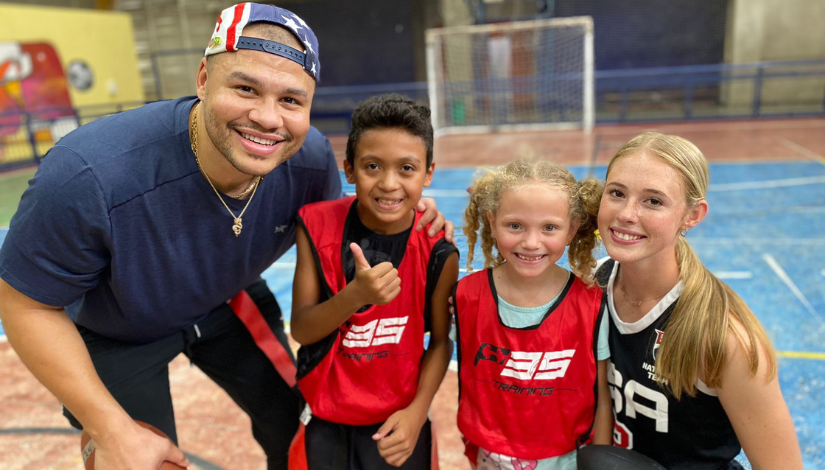 Foto com os dois jogadores da NFL e duas crianças que participaram do evento.