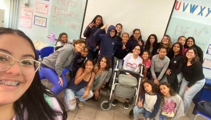 Fotografia mostra vinte e duas pessoas posando para foto em formato selfie.