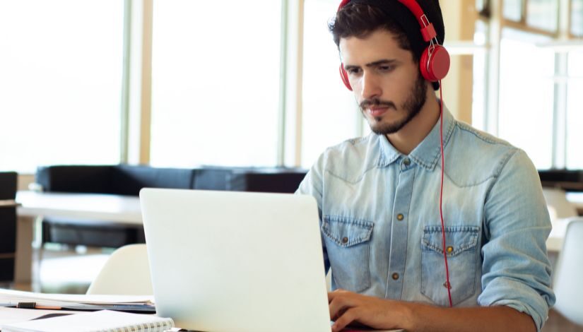 Homem de fone vermelho mexendo no computador