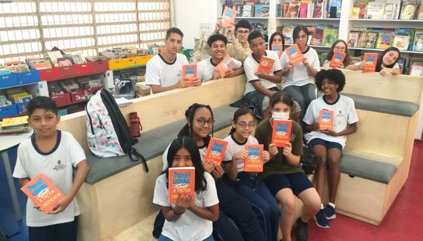 Fotografia mostra vários estudantes da EMEF Eduardo Prado segurando o livro do Pedro Bandeira, 