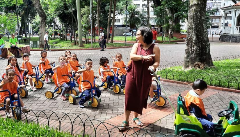 Professora Lívia e várias crianças andando de motoca na Praça da república.