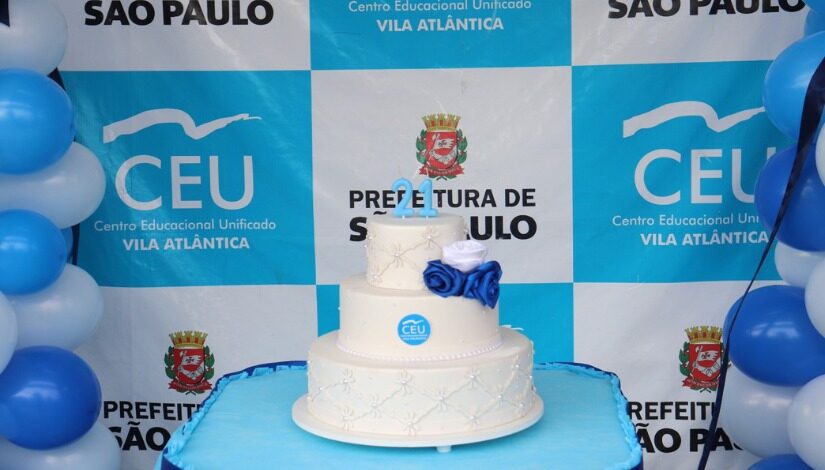 Fotografia de um bolo branco com azul - Ceu Vila Atlântica Celebra 21 Anos