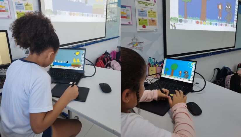 Estudantes utilizando computador e a mesa digitalizadora.