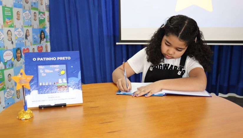 Estudante assinando o livro coletivo