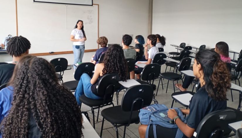 Fotografia de estudantes e professora em sala de aula.