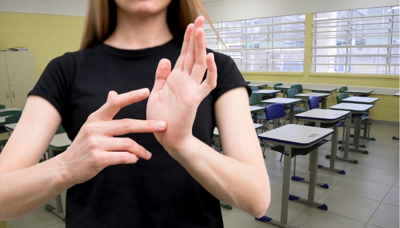 fotografia de professor fazendo libras em uma sala de aula