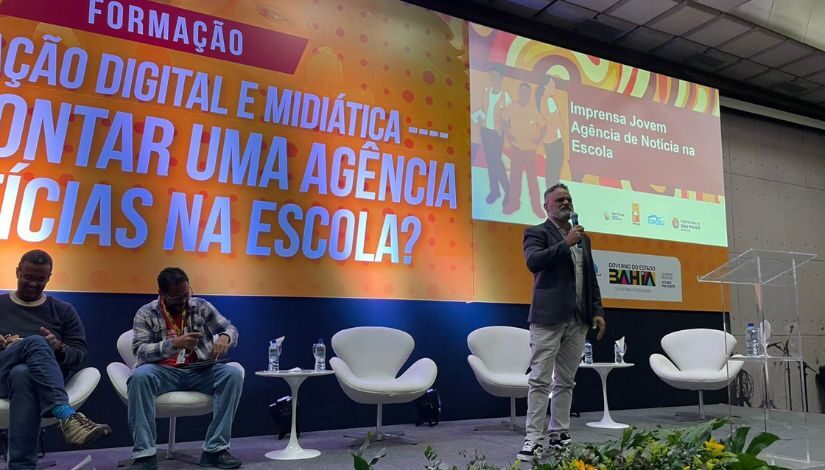 Fotografia mostra o coordenador do Imprensa Jovem em formação no palco do evento.