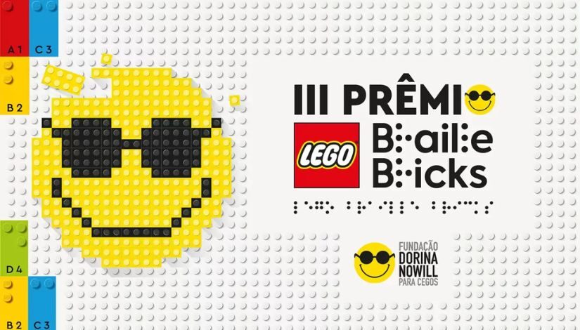 Imagem composta de peças de lego ao centro está escrito Prêmio Braille Bricks Lego com fundo branco e o emoji amarelo sorrindo e com óculos.