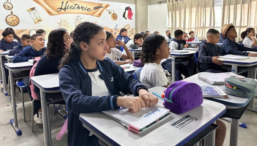 Fotografia de uma sala de aula com estudantes em suas classes e uniforme da PMSP ilustram curso sobre busca ativa escolar.