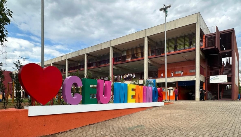 Facha de um prédio com um letreiro colorido na frente escrito 