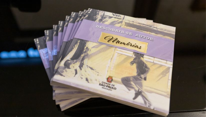 Imagem de uma pilha de livros sob uma mesa preta com o título 