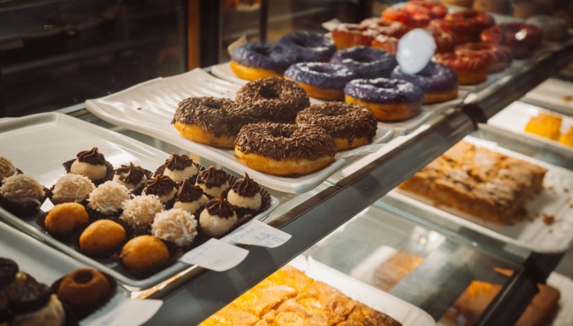 Fotografia de uma mesa com diversos doces e rosquinhas.