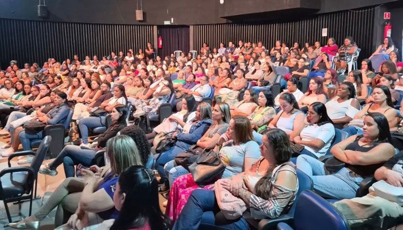 Fotografia de um auditório lotado com inúmeras pessoas sentadas.