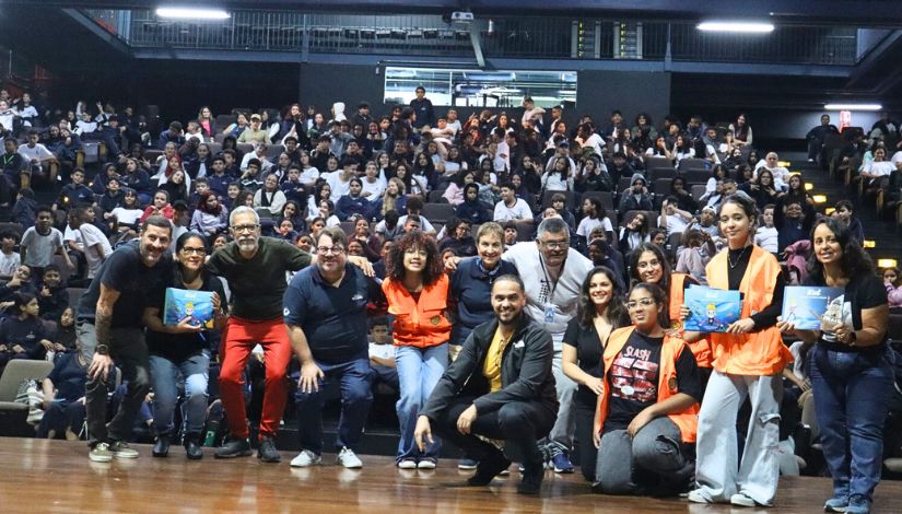 Auditório do CEU Vila Curuçá repleto de estudantes que posam para foto junto com a escritora Heloisa Schurmann.