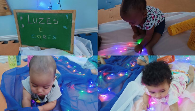 Montagem com quatro imagens de um ambiente sensorial voltado a bebês. Na primeira, há um pequeno quadro verde com a inscrição “Luzes e Cores”, apoiado sobre tecidos claros e iluminação suave. Nas demais imagens, bebês exploram o espaço deitados sobre panos coloridos, interagindo com luzes decorativas multicoloridas. Eles tocam, observam e se aproximam das luzes, demonstrando curiosidade e concentração. O ambiente é acolhedor, com cores suaves, tecidos e elementos que estimulam os sentidos.